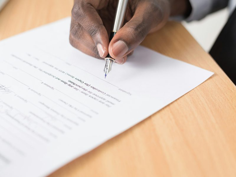 Hand signing a contract with a fountain pen
