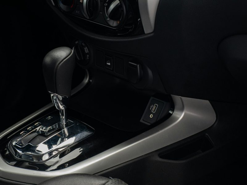 A close up of a car's gear box and steering wheel
