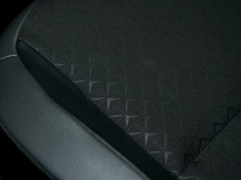 A black car seat with a subtle geometric diamond pattern on the fabric