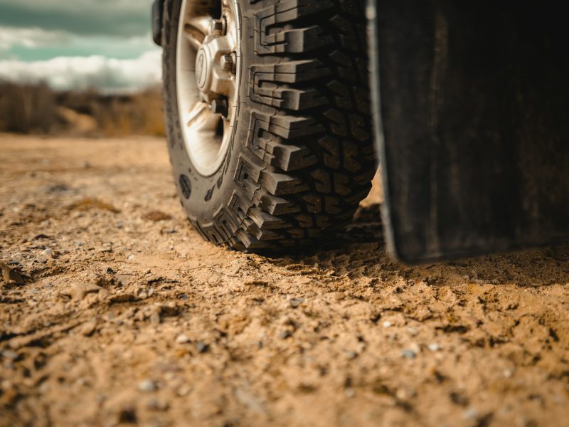 Black car tire on brown sand during daytime