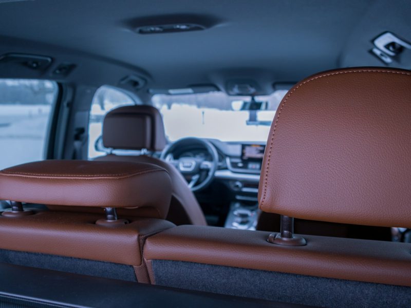 The inside of a vehicle with a brown leather seat