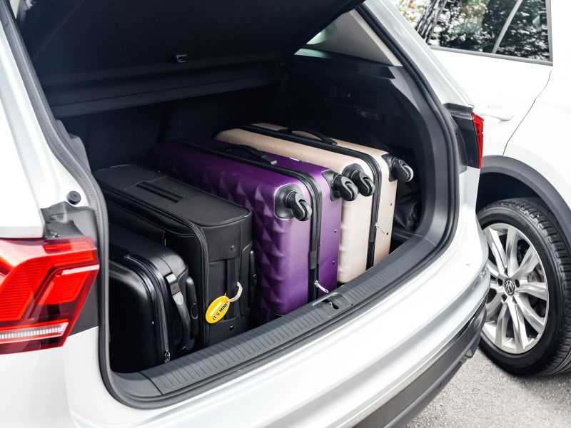 Suitcases packed in the cargo area of a white SUV