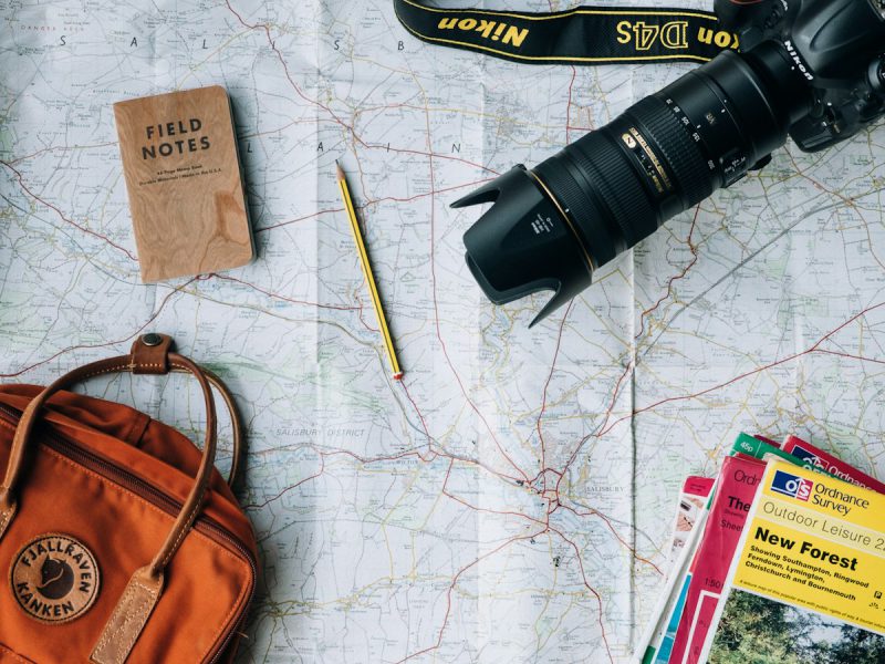Flat lay of a camera, a book and a bag