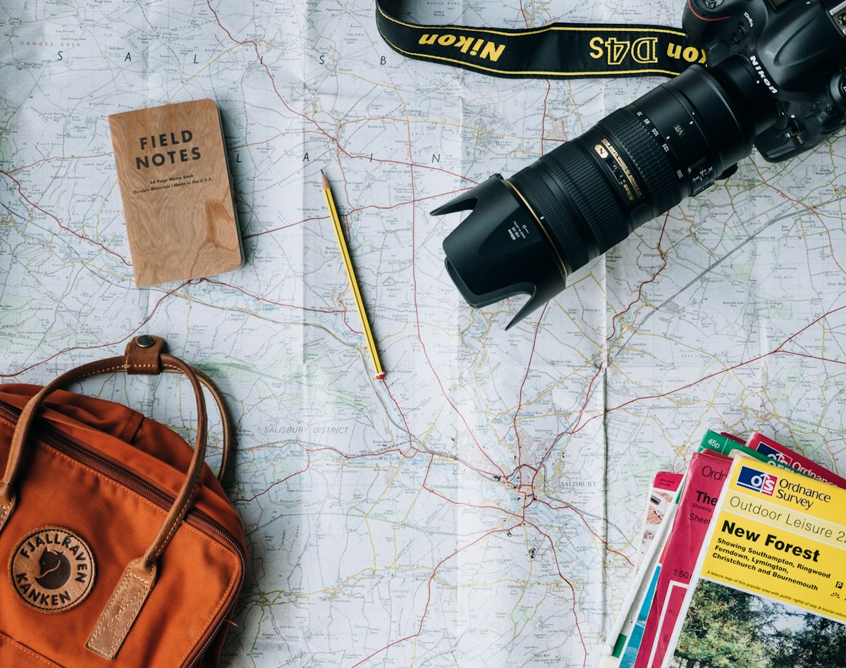 Flat lay of a camera, a book and a bag