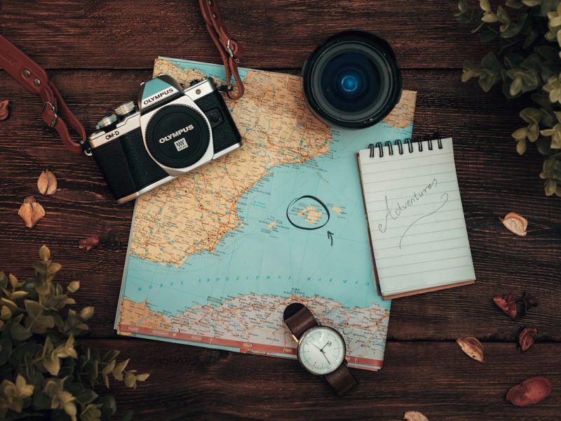 A map, a camera and a watch laid out on a table