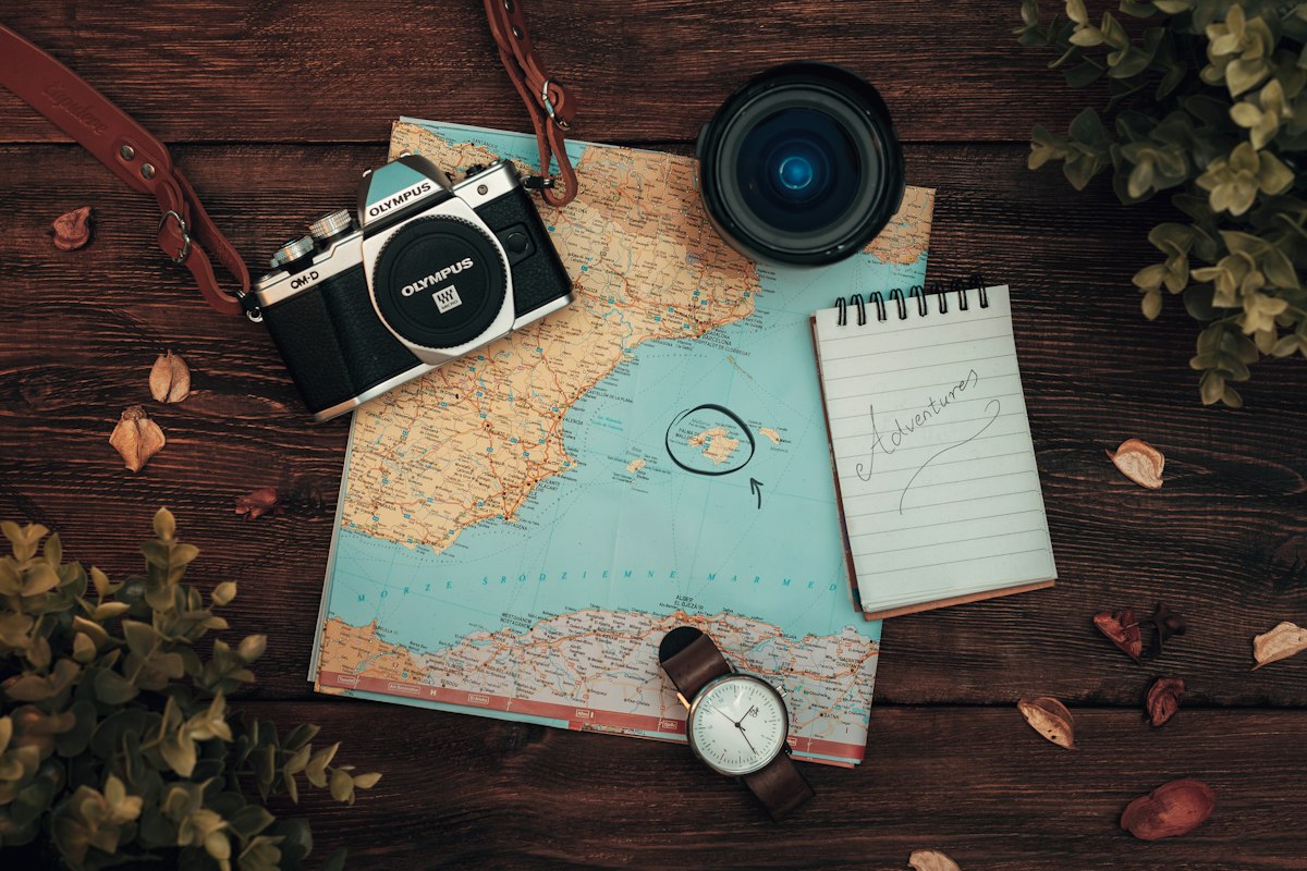 A map, a camera and a watch laid out on a table