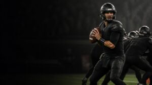 A quarterback set in the pocket scans downfield behind his line.
