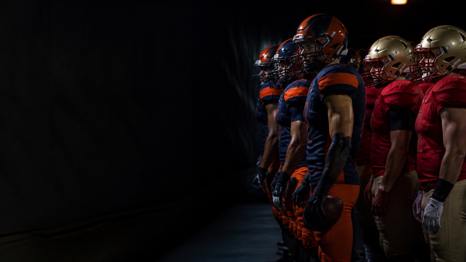 Players from both sides wait side by side in the tunnel.